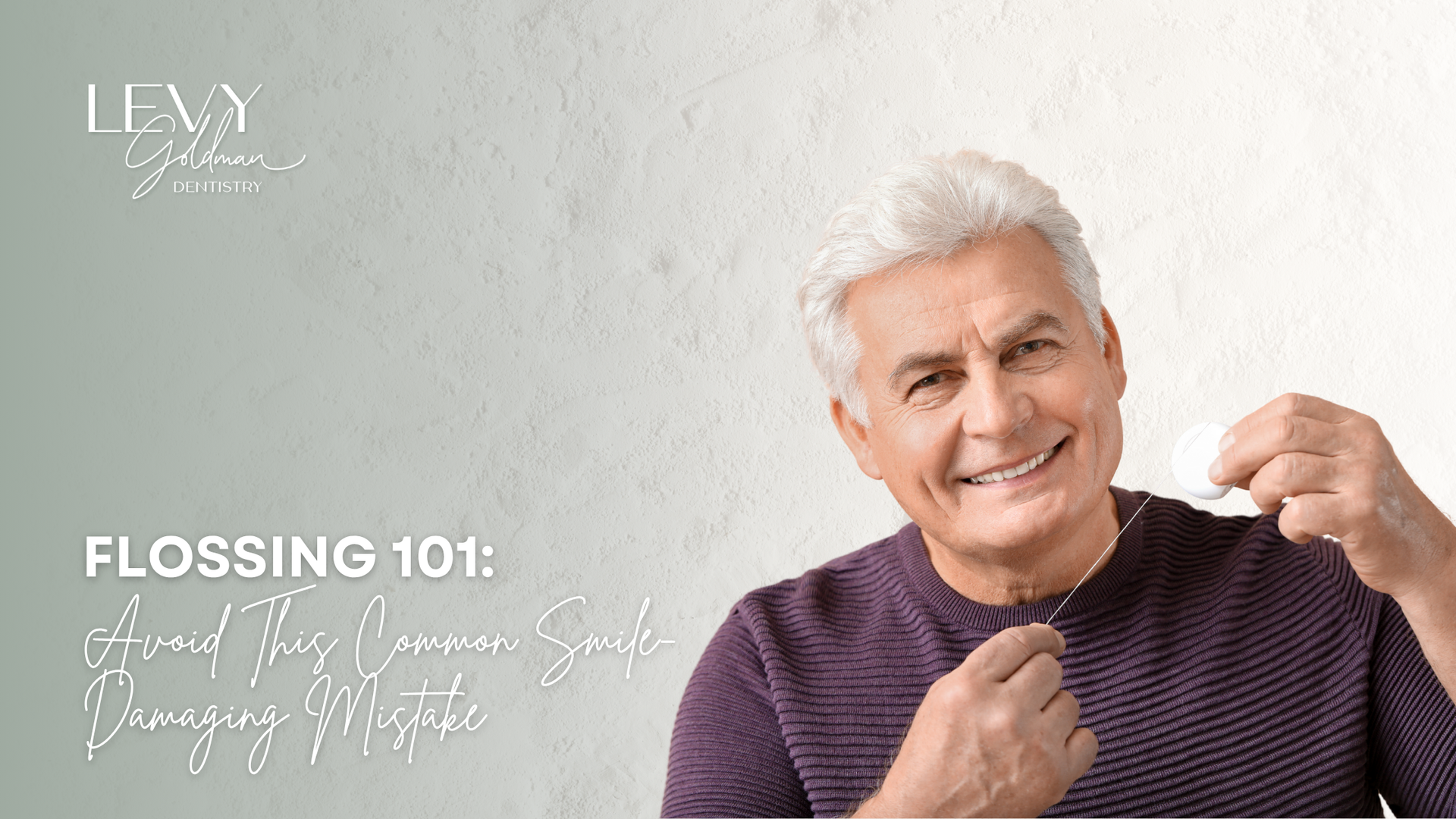 An older man is flossing his teeth and smiling.