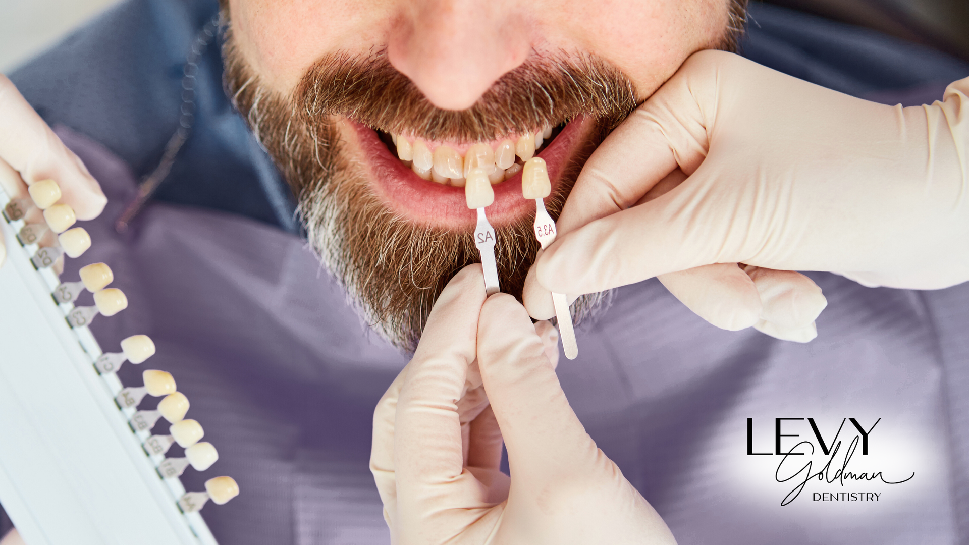 A man with a beard is getting his teeth examined by a dentist.