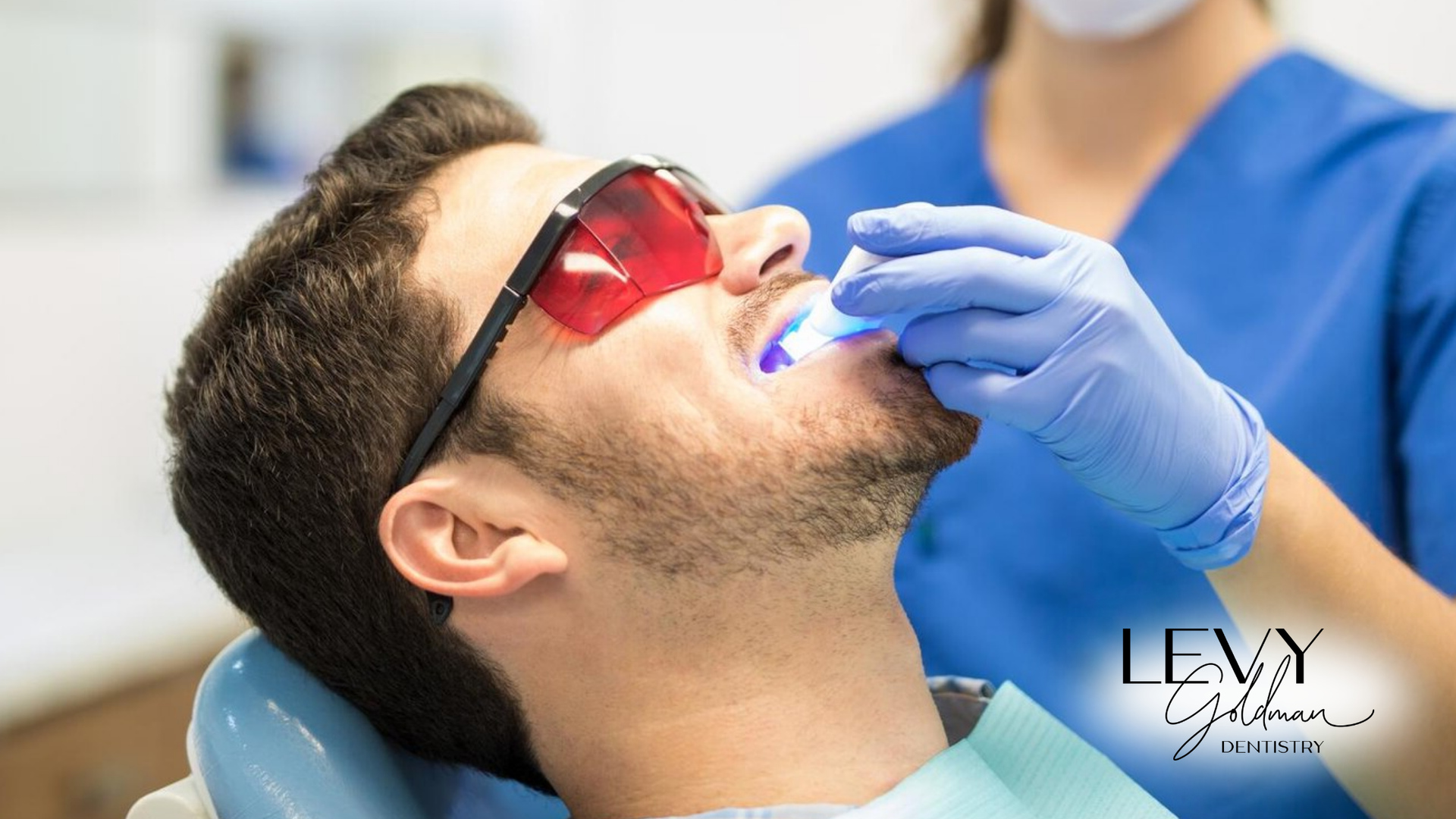 A man is getting his teeth whitened by a dentist.