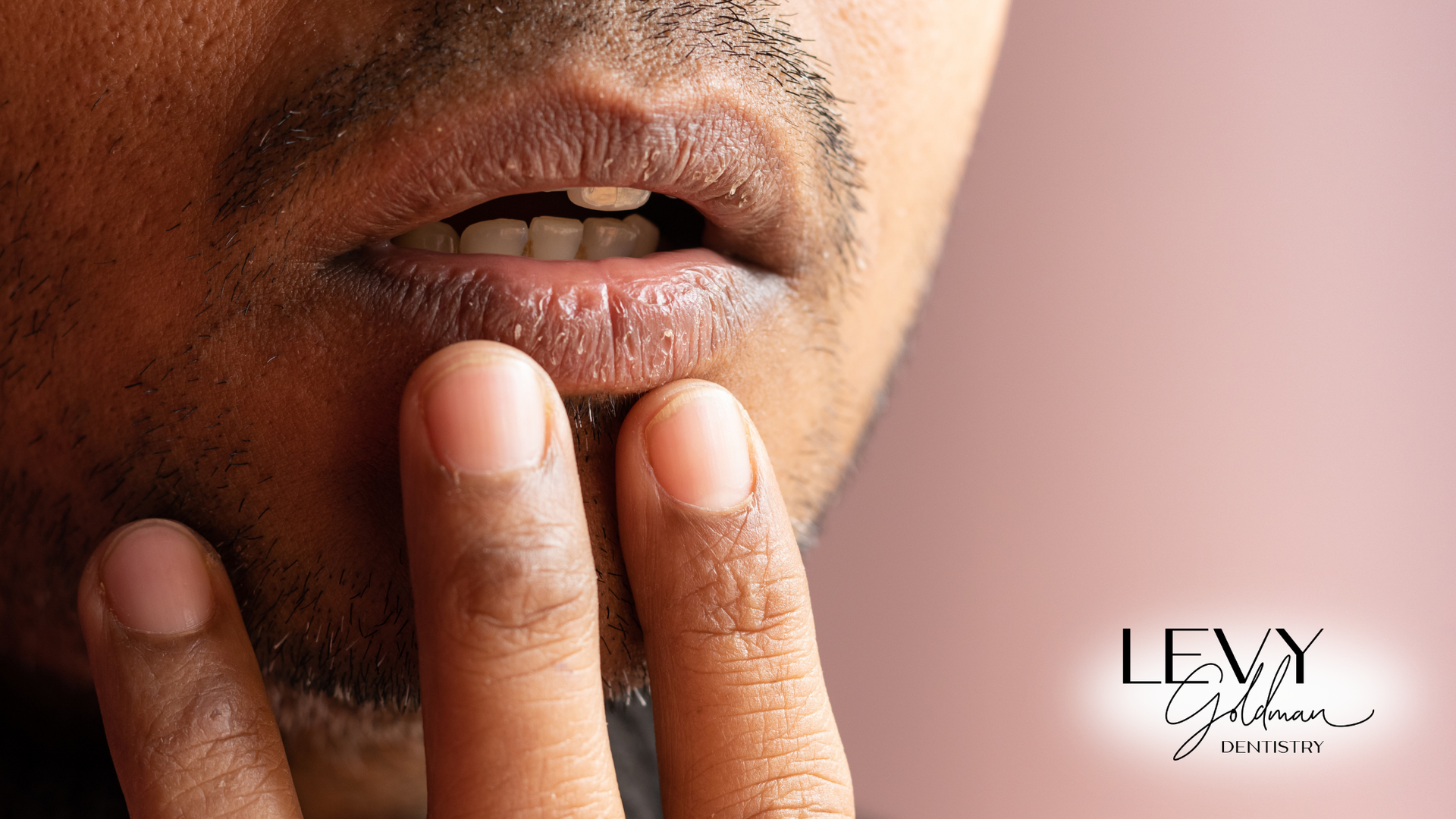 A close up of a man covering his mouth with his hand.