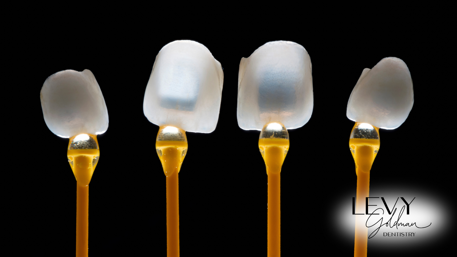 A row of dental veneers for teeth on yellow sticks