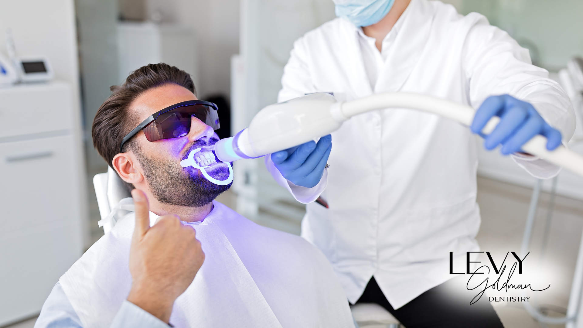 A man is getting his teeth whitened by a dentist.