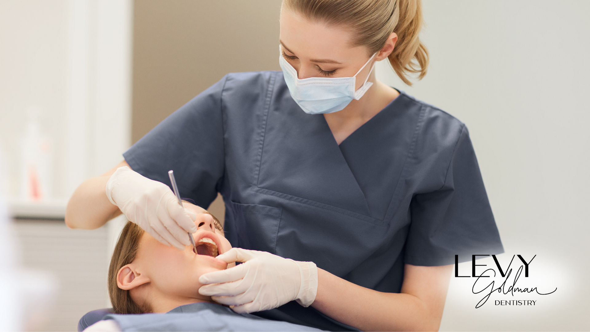 A female dentist is examining a child 's teeth in a dental office.