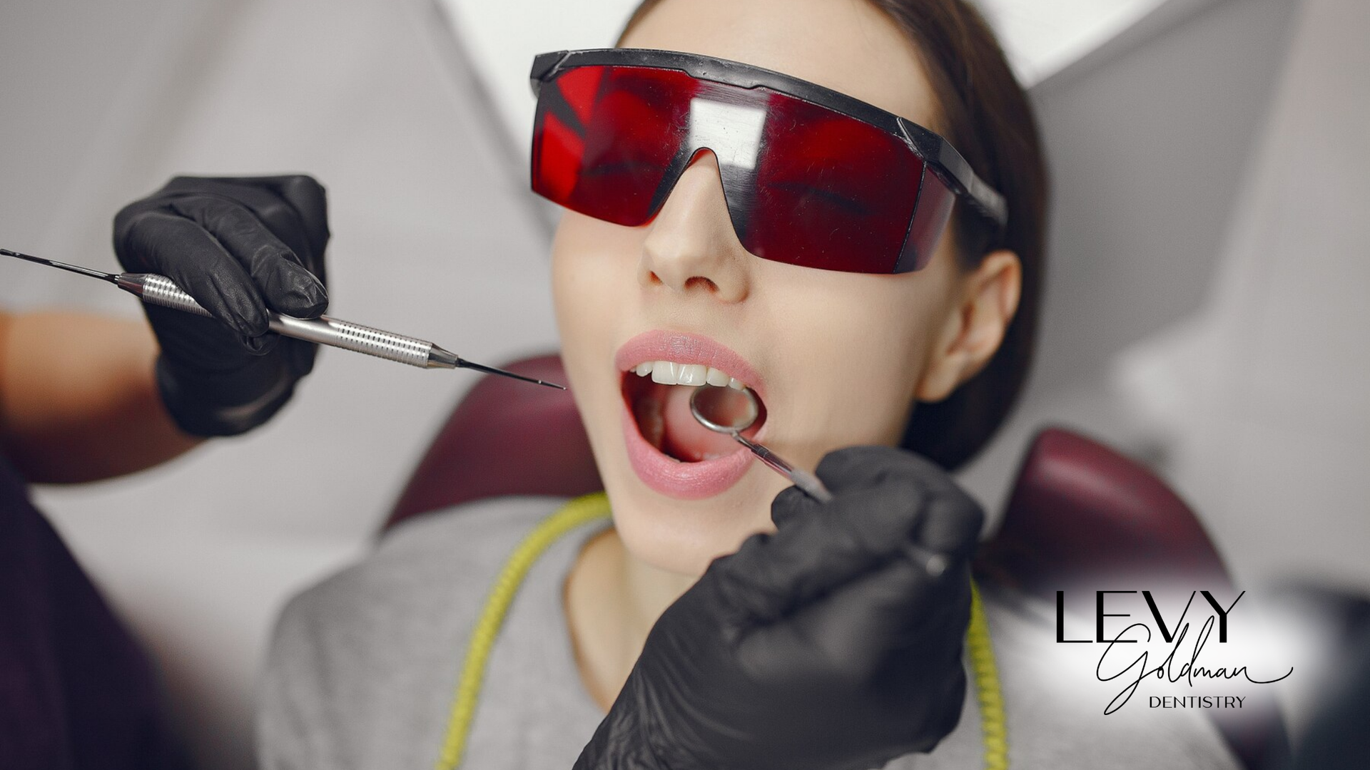 A woman is getting her teeth examined by a dentist.