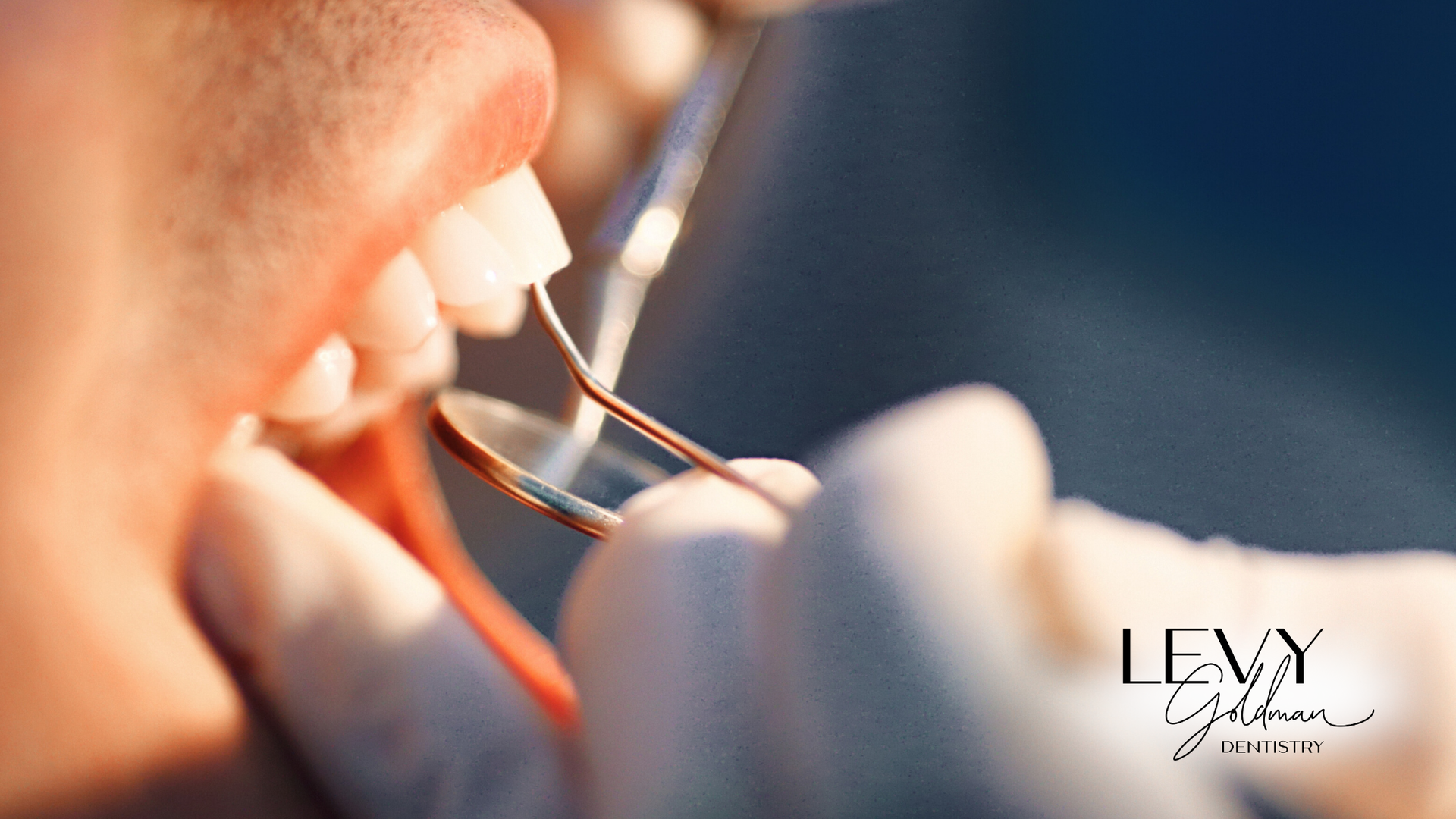 A dentist is examining a patient 's teeth with tweezers.