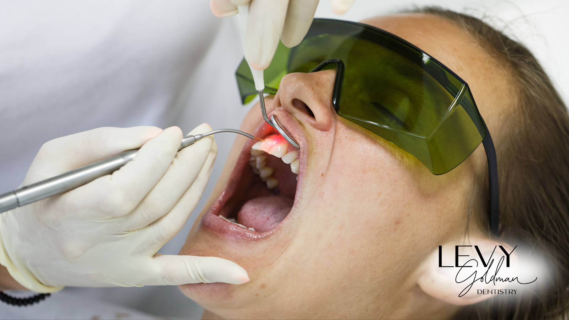 A woman is getting her teeth examined by a dentist.