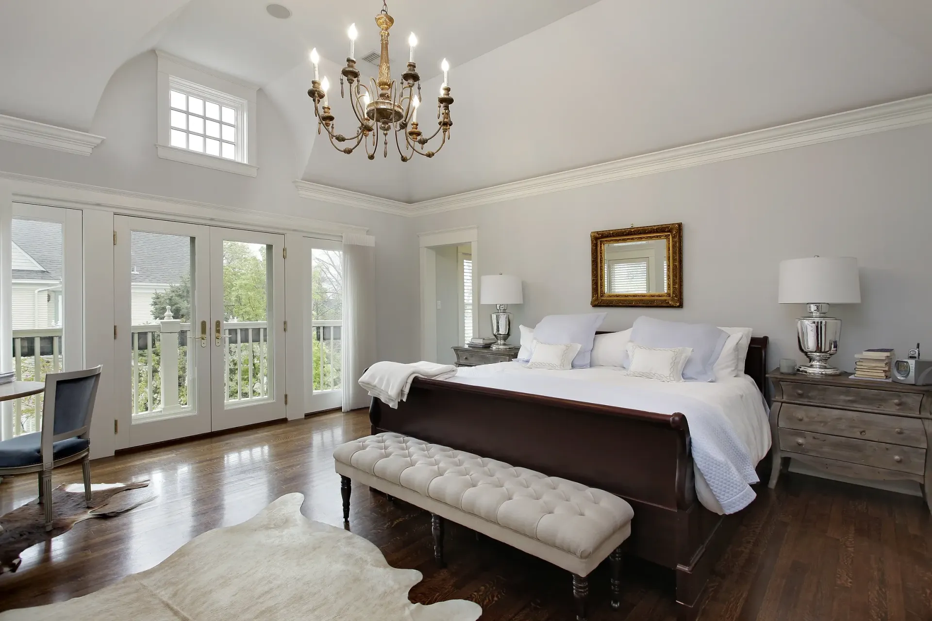 A bedroom with a large bed and a chandelier