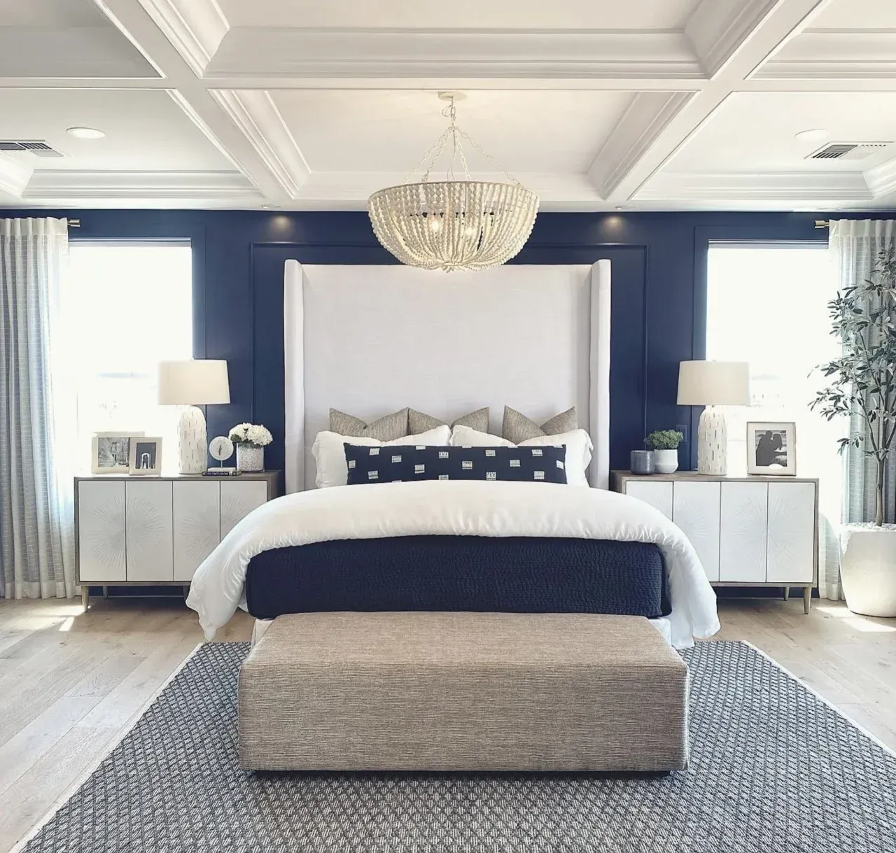 A bedroom with blue walls and a white bed