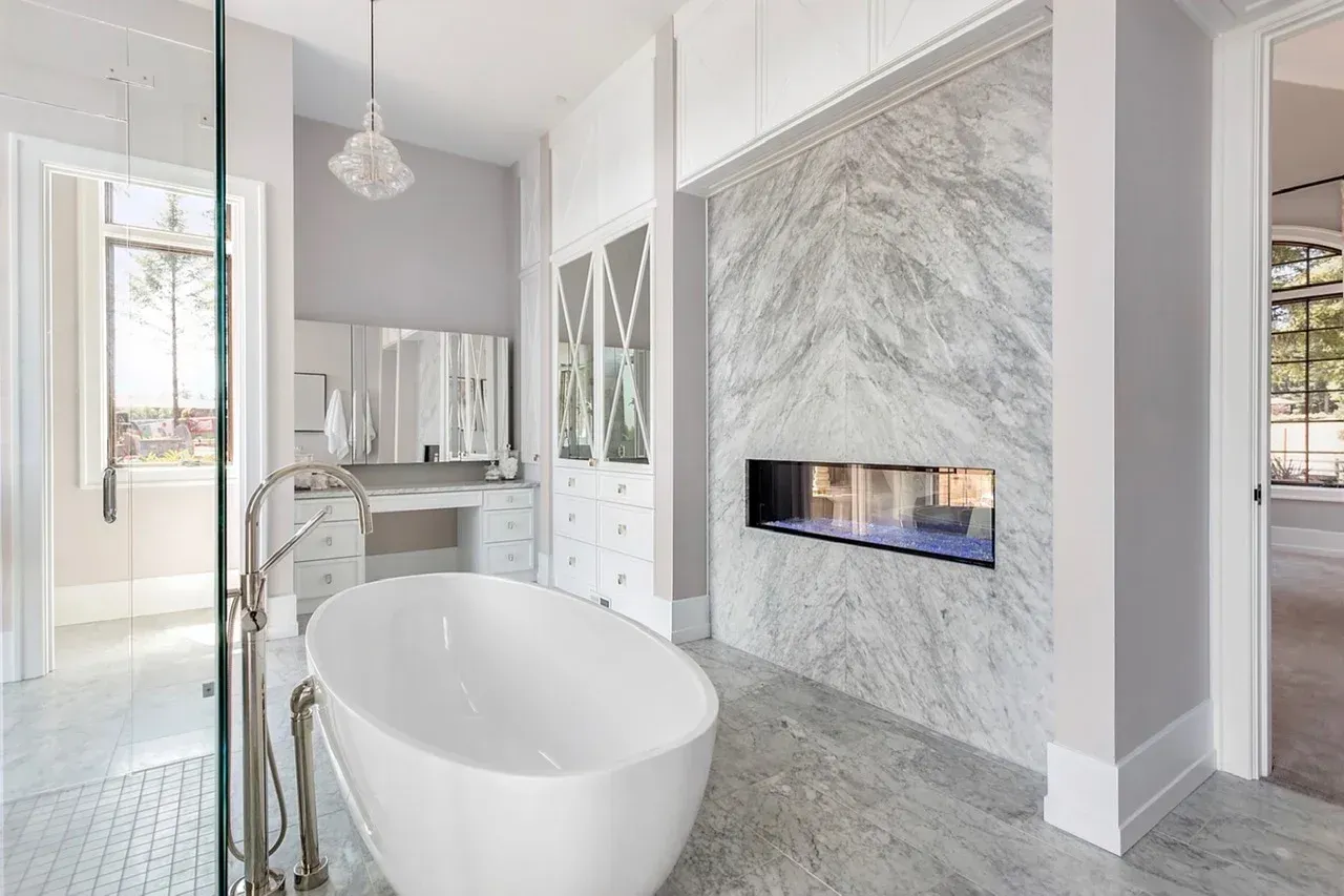 A bathroom with a tub and a fireplace.