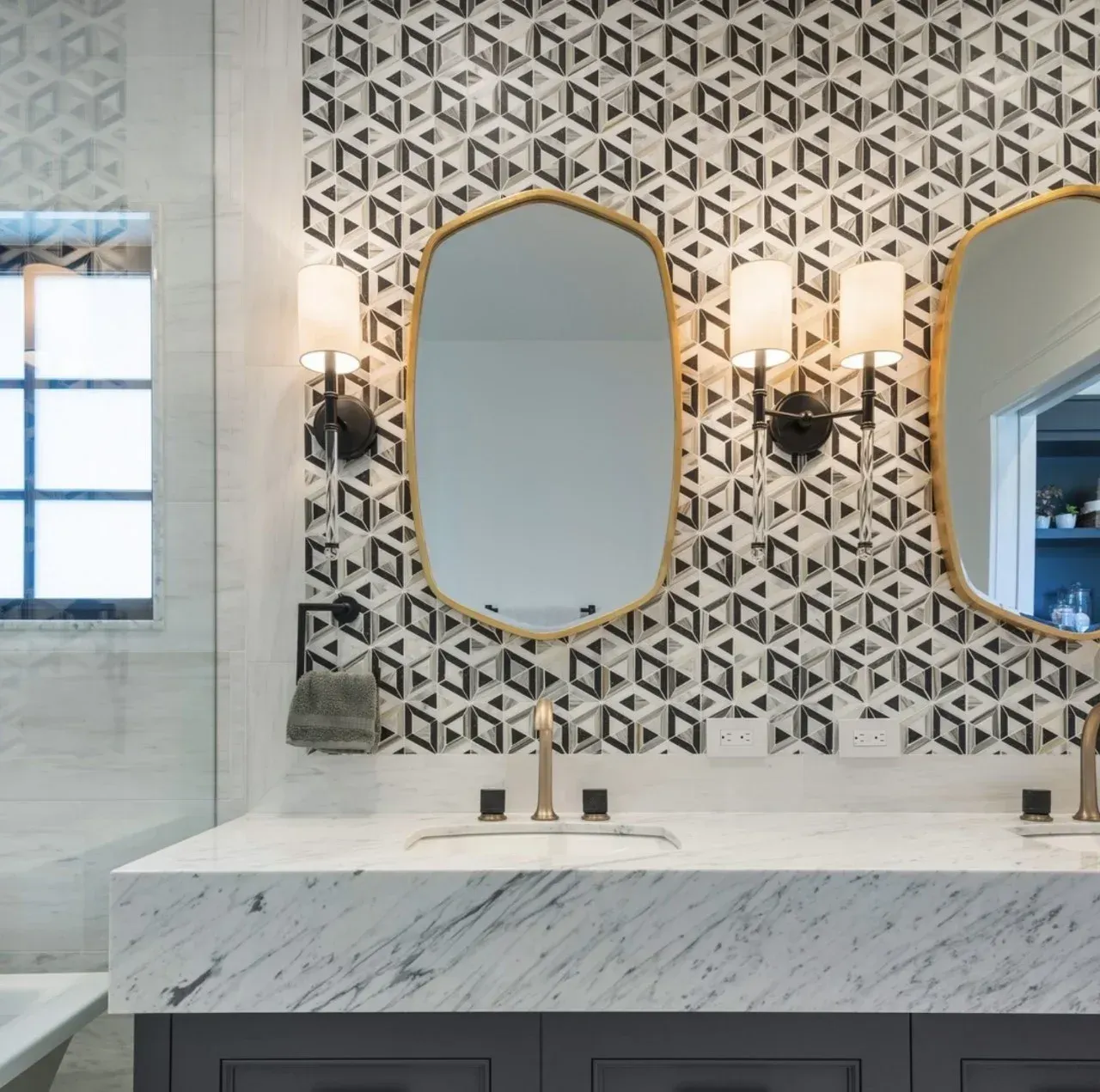 A bathroom with two mirrors and a patterned wall
