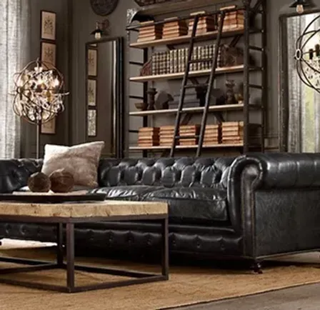 A living room with a black leather couch and a wooden coffee table