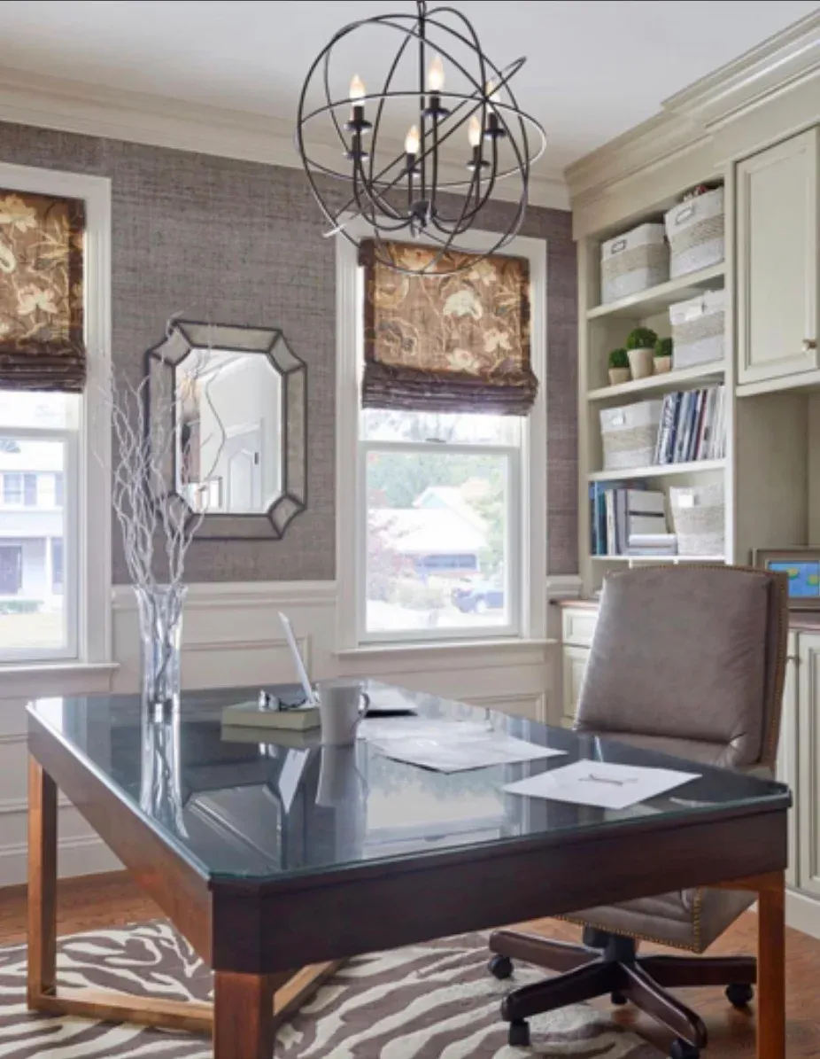 A home office with a desk and chair and a chandelier