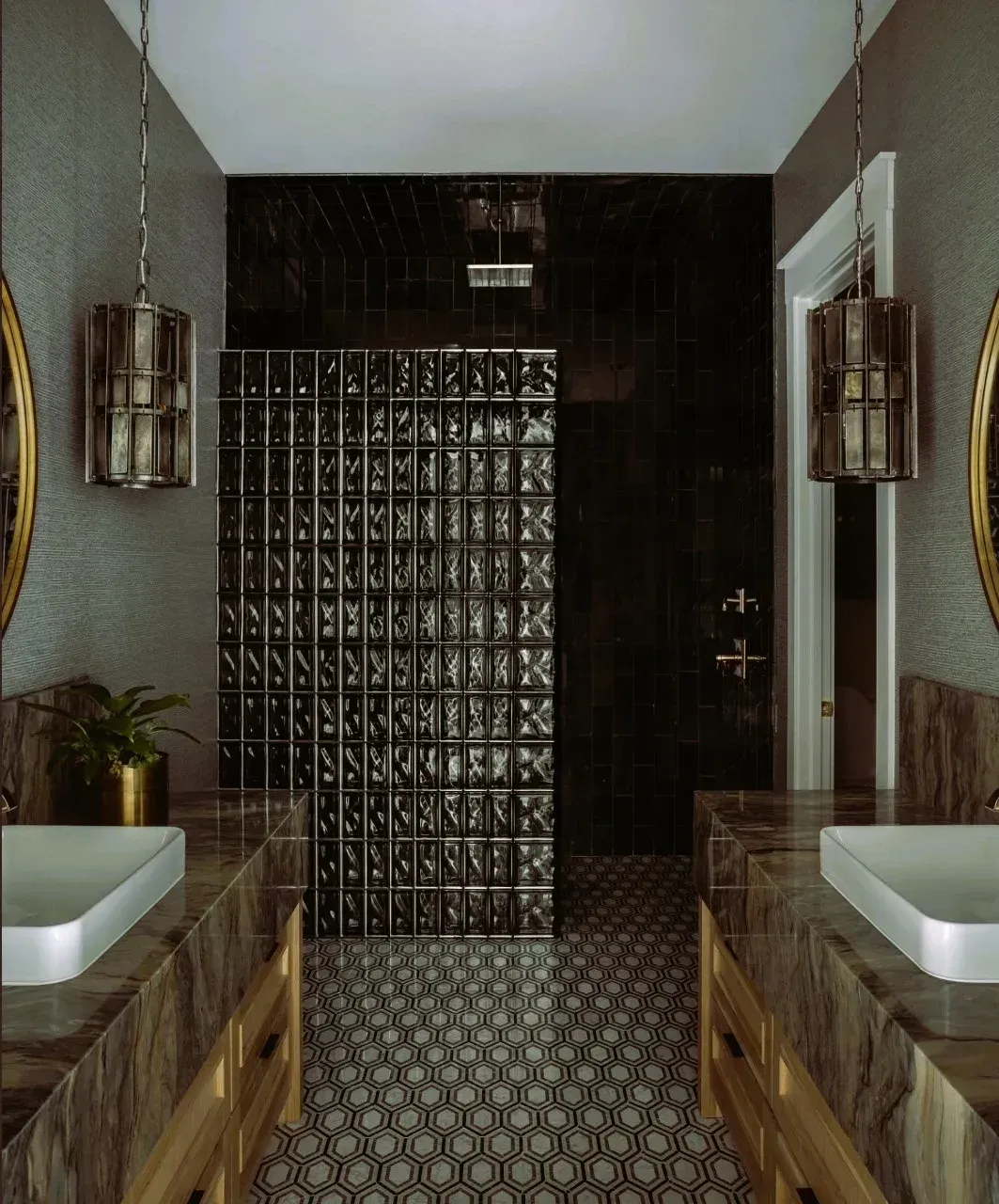 A bathroom with two sinks and a walk in shower