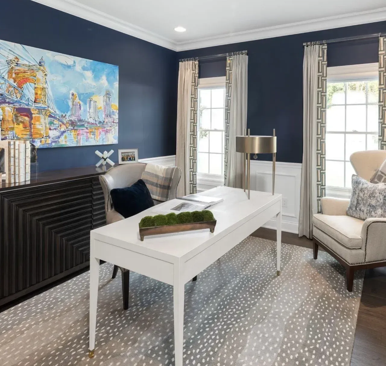 A home office with blue walls and a white desk
