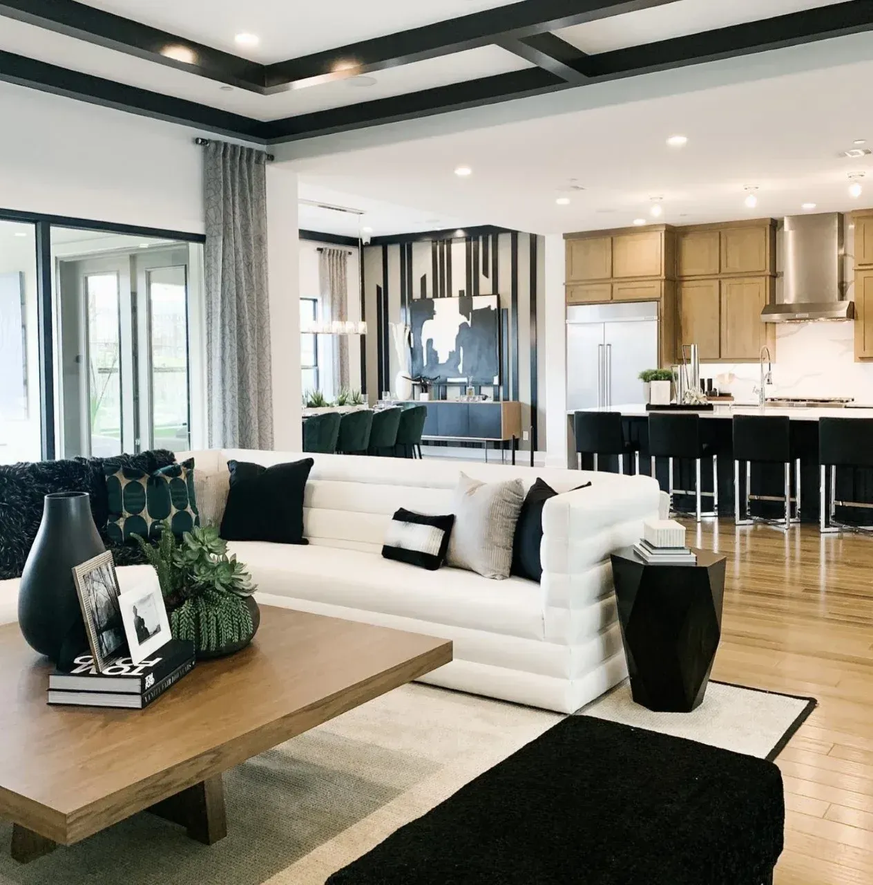 A living room with a white couch and black pillows