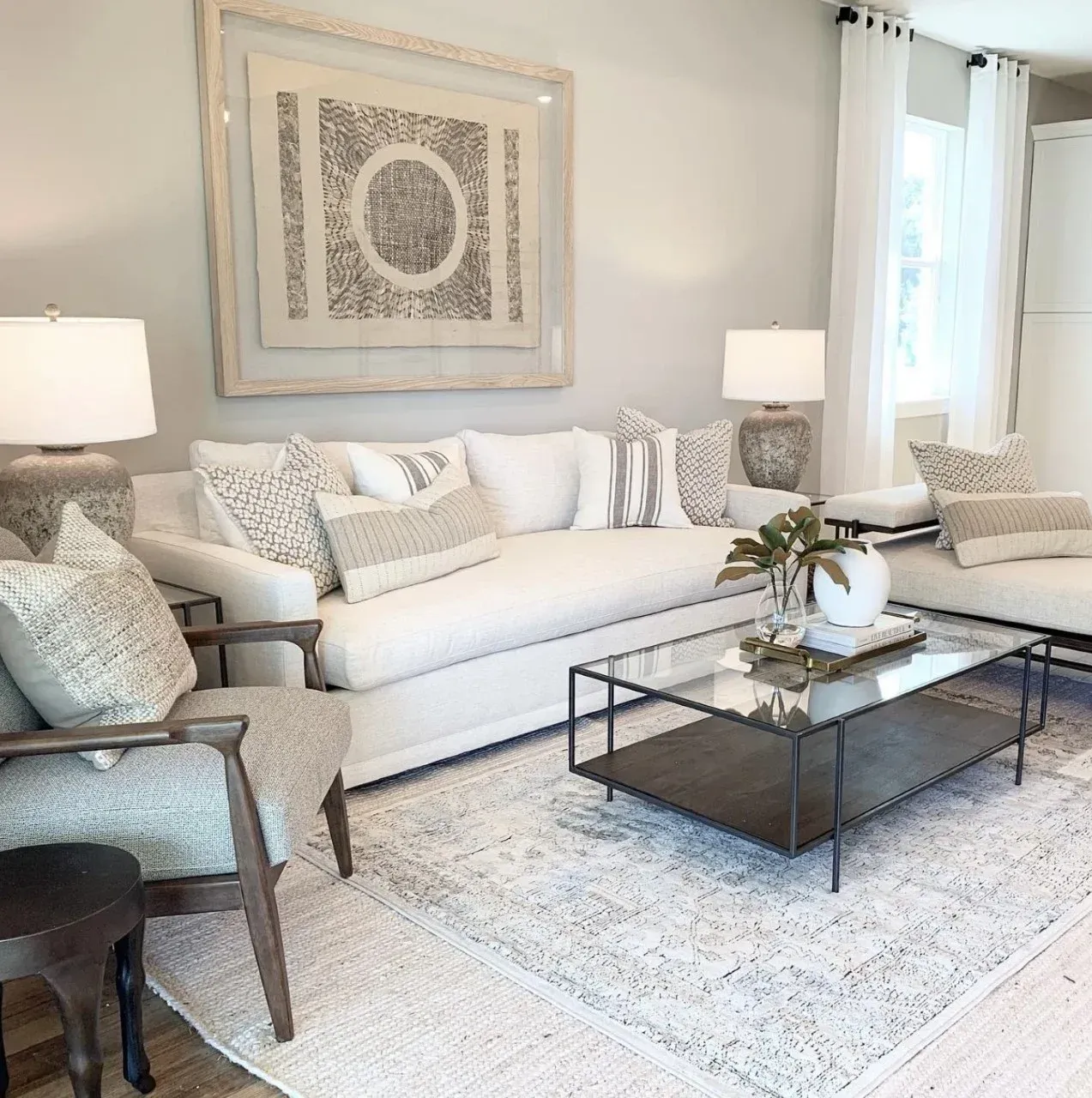 A living room with a white couch and a glass coffee table