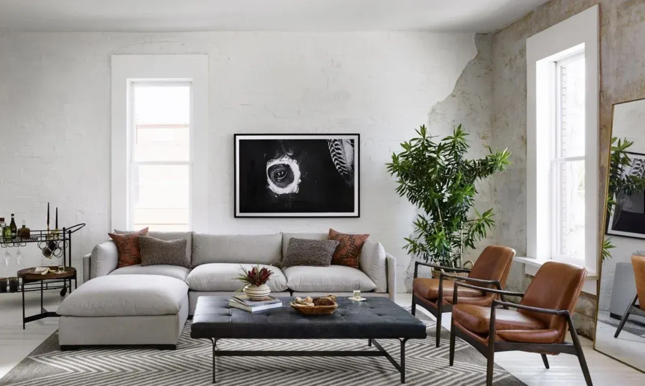 A living room with a couch , chairs , a coffee table and a television.