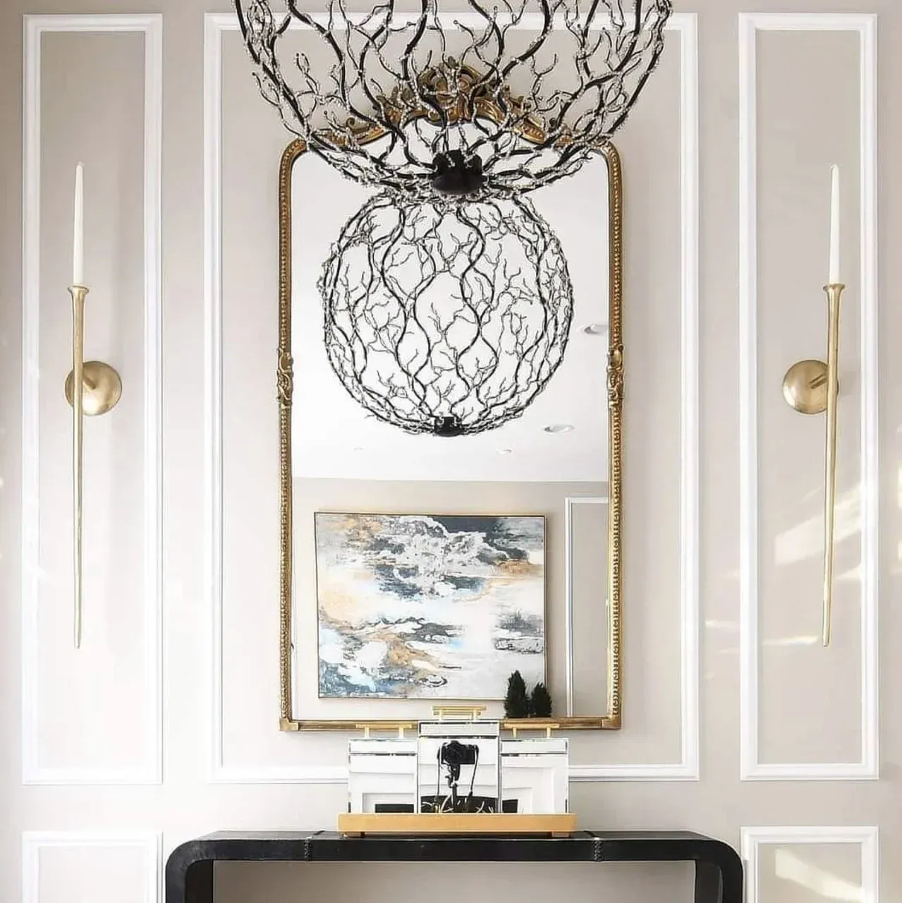 A hallway with a mirror and a painting on the wall