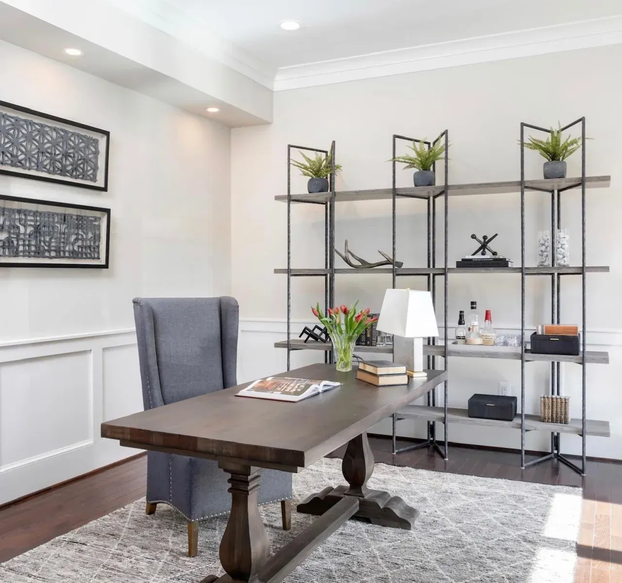A home office with a desk and chairs and shelves