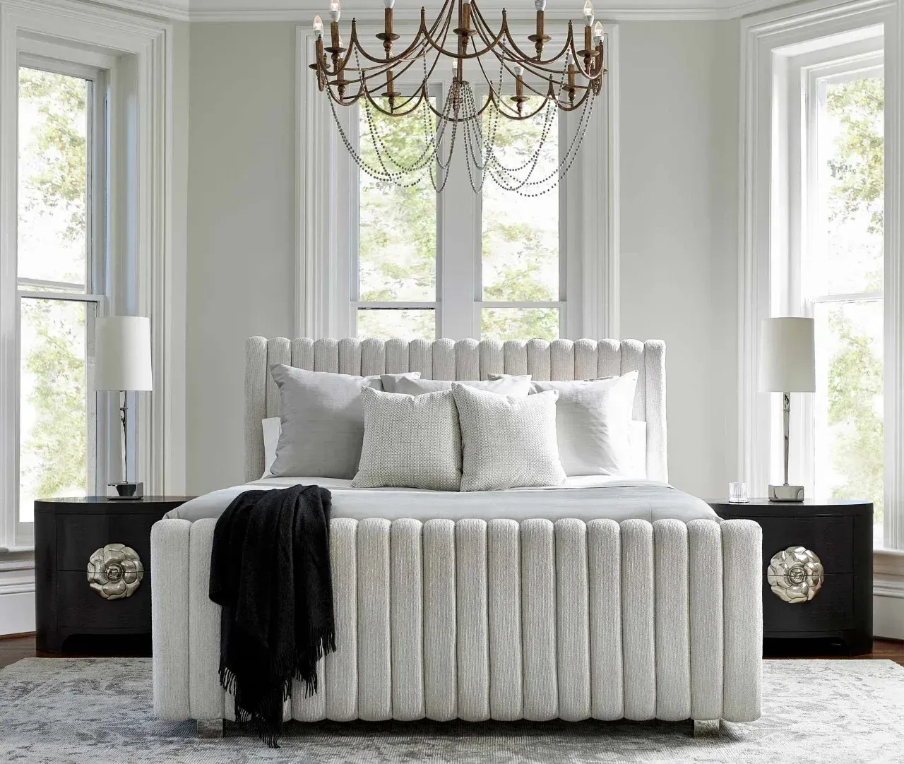 A bedroom with a bed , nightstands , and a chandelier.