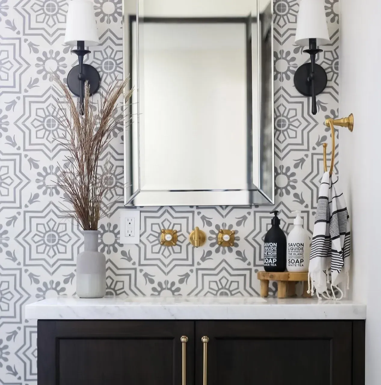 A bathroom with a mirror and a vase of flowers