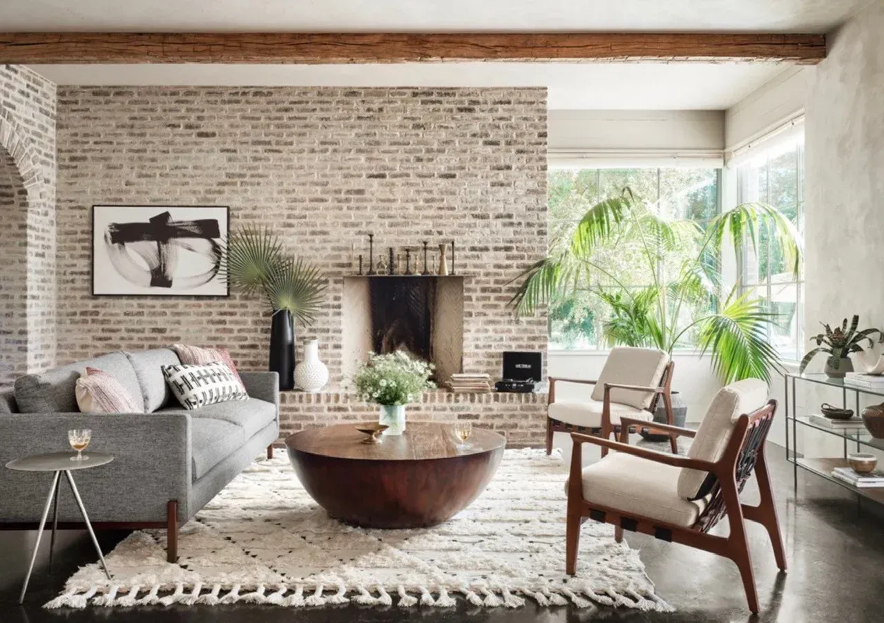 A living room with a couch , chairs , coffee table and fireplace.