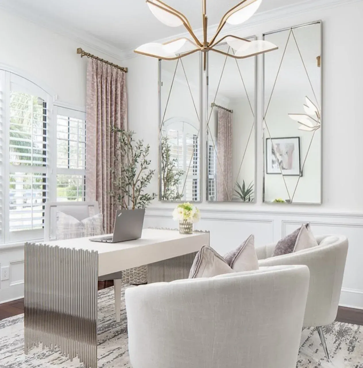 A living room with two chairs and a desk with a laptop on it