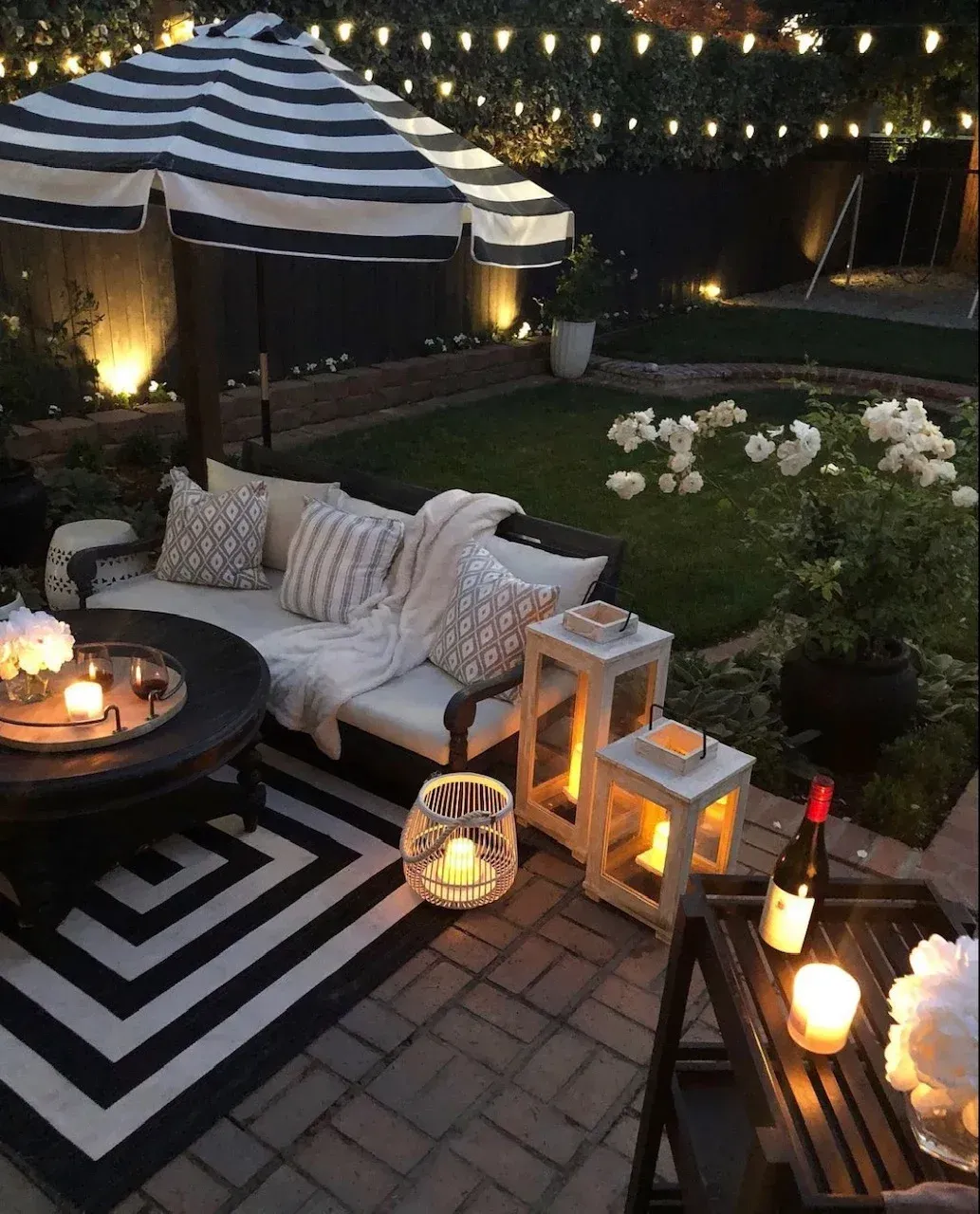 A black and white patio with a striped umbrella