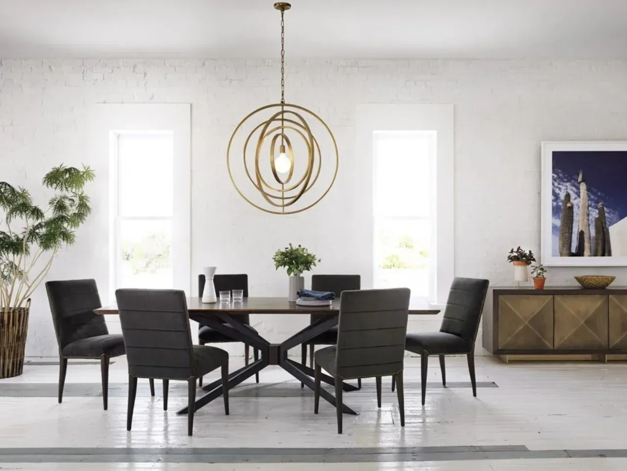 A dining room with a table and chairs and a chandelier hanging from the ceiling.