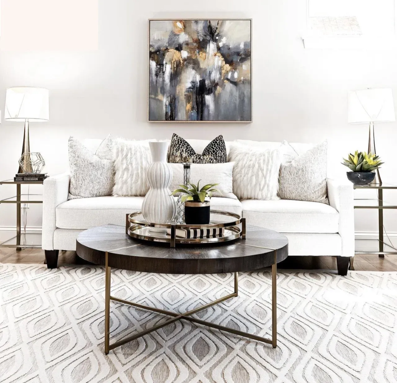 A living room with a white couch and a round coffee table.