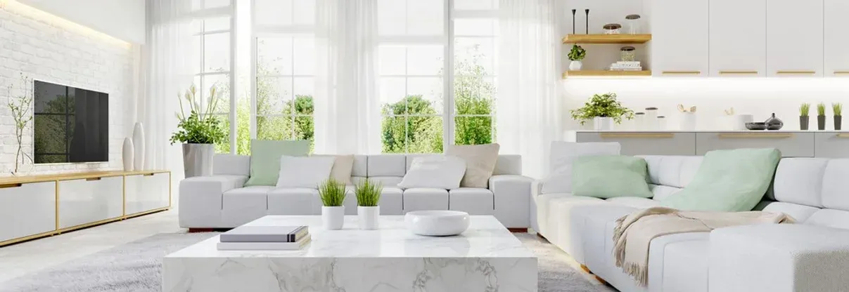 A living room with white furniture and a marble coffee table.