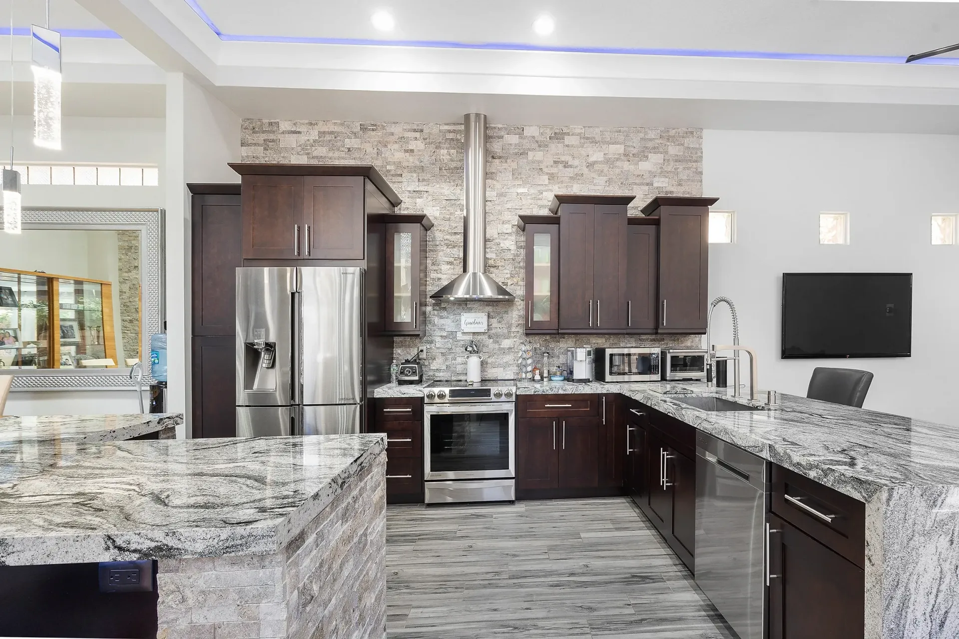 A kitchen with granite counter tops and stainless steel appliances.