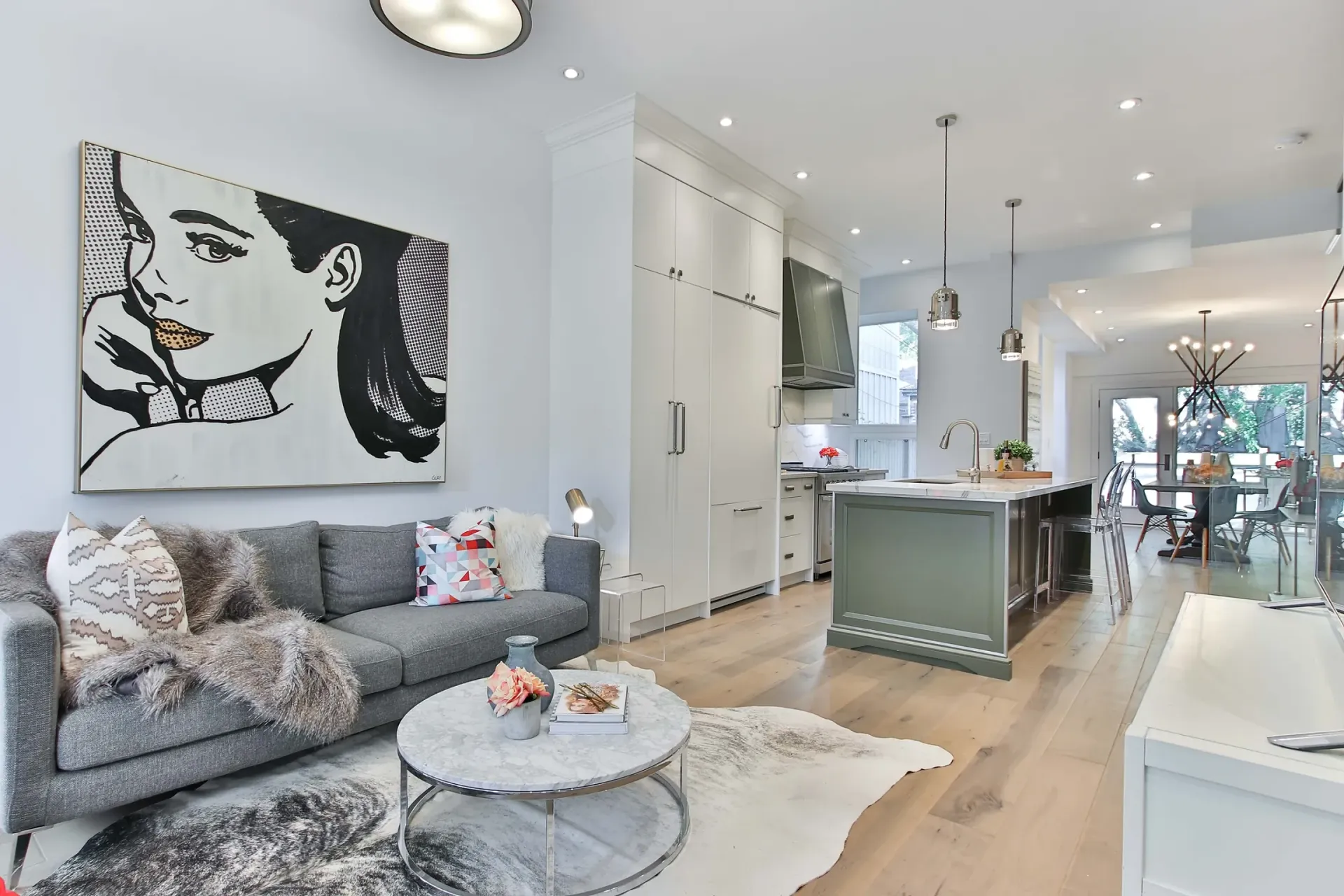 A living room with a couch , coffee table , rug and painting on the wall.