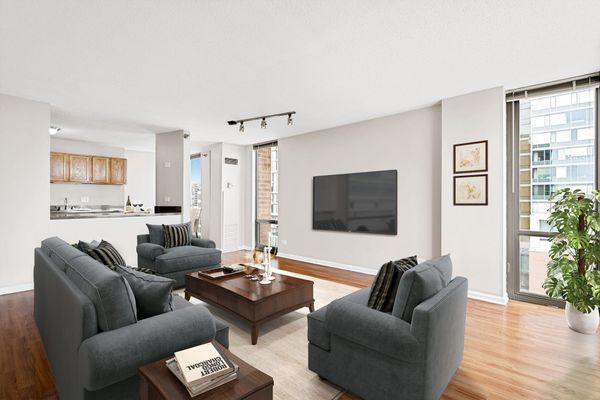 A living room with a couch , two chairs , a coffee table and a flat screen tv at 100 Forest Place 