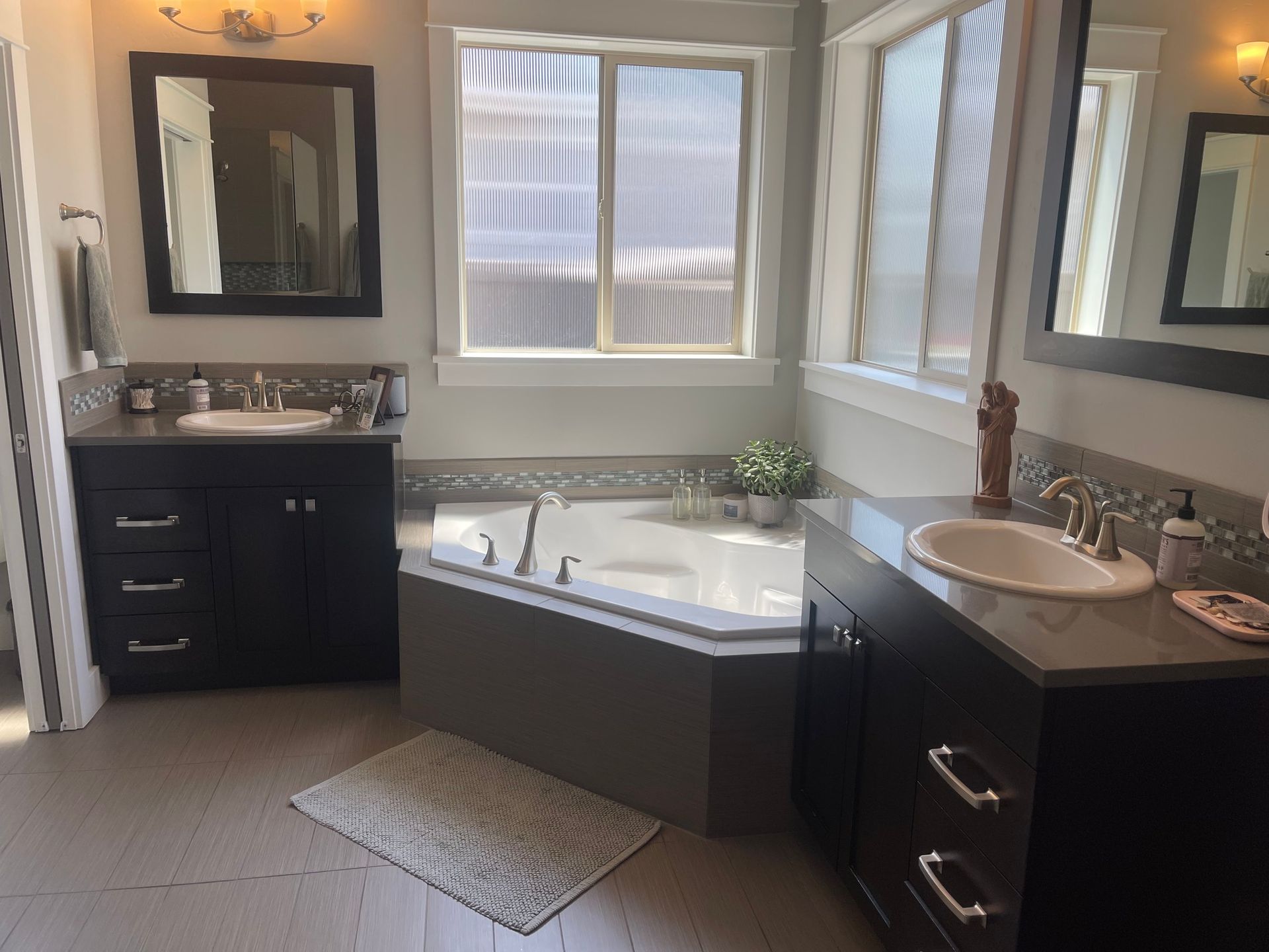 A bathroom with two sinks and a jacuzzi tub.