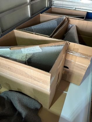 Des cartons doublés de papier bulle sont emballés les uns contre les autres dans un espace de stockage ou un camion.