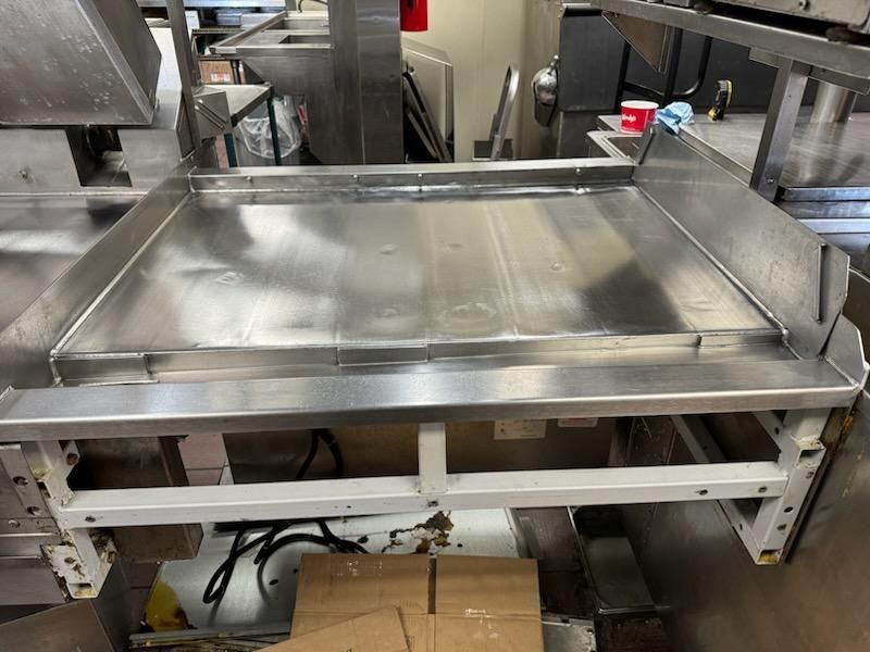 A stainless steel tray is sitting in a kitchen next to boxes.