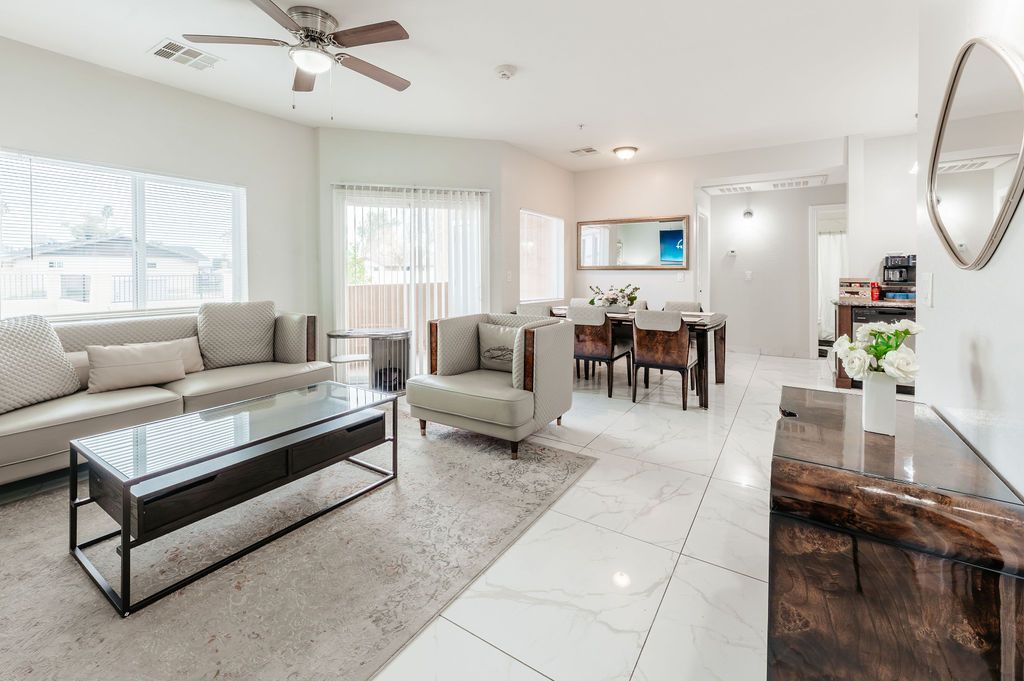 Spacious, bright living room with neutral colors, furniture, and a dining area.