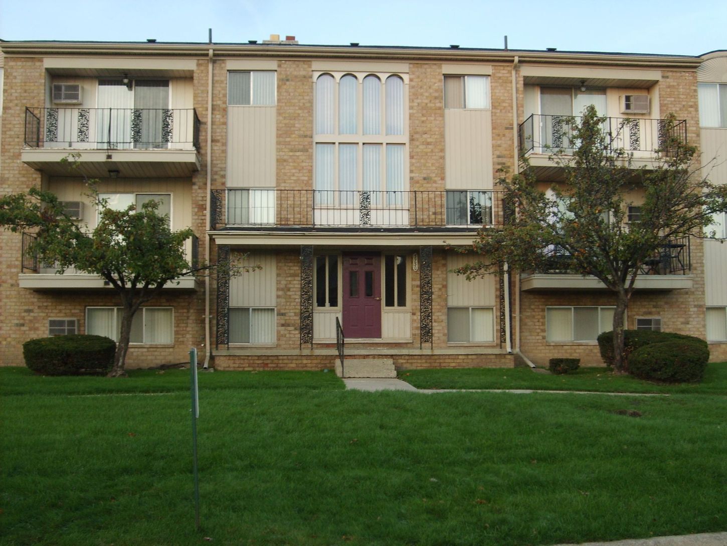 A brick apartment building with a purple door