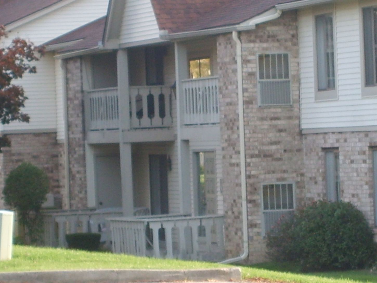 A brick apartment building with a balcony on the second floor