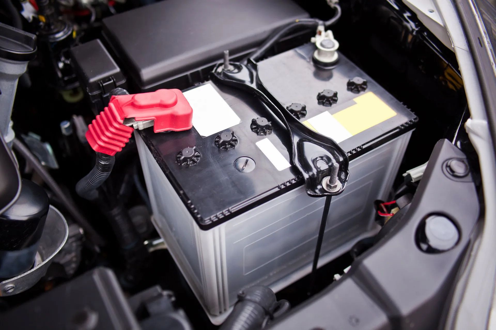 A car battery is sitting under the hood of a car