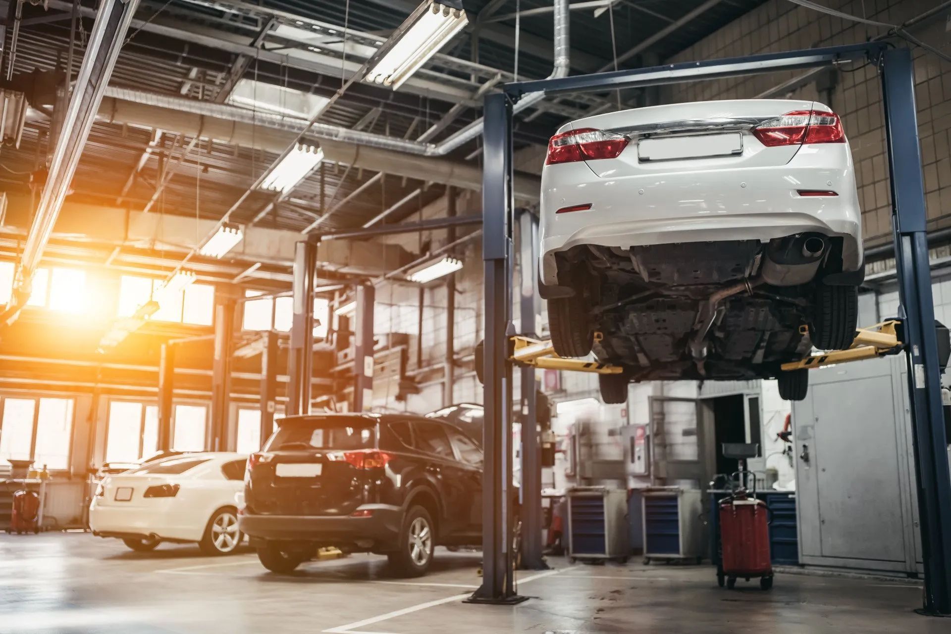 A car is sitting on a lift in a garage.