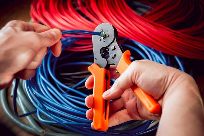 a person is using a crimping tool to cut a wire.