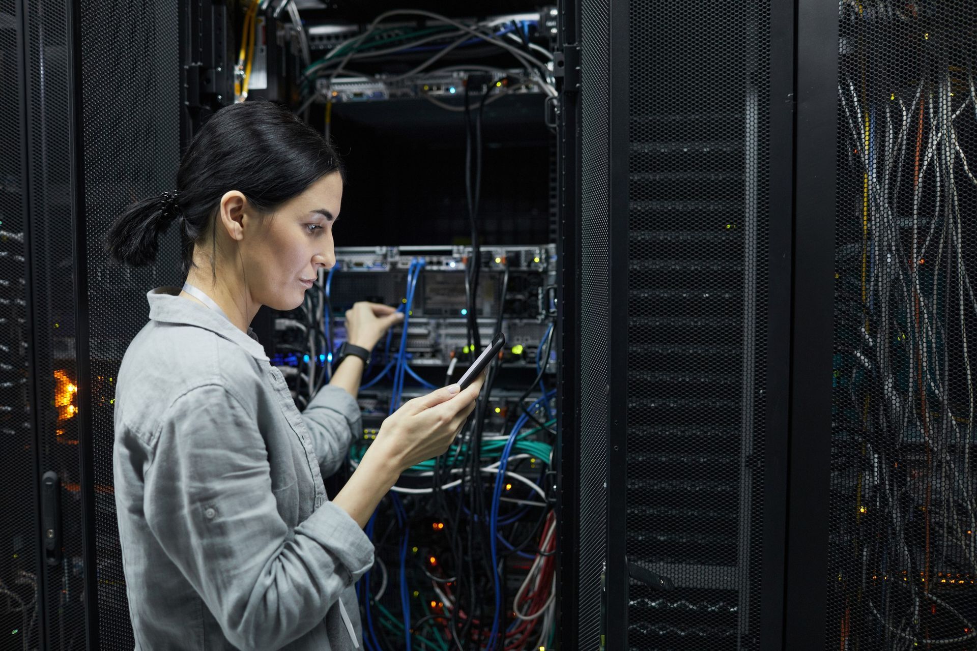 a woman is working on a server in a data center .