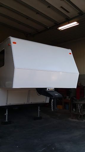 A white trailer is sitting in a garage.