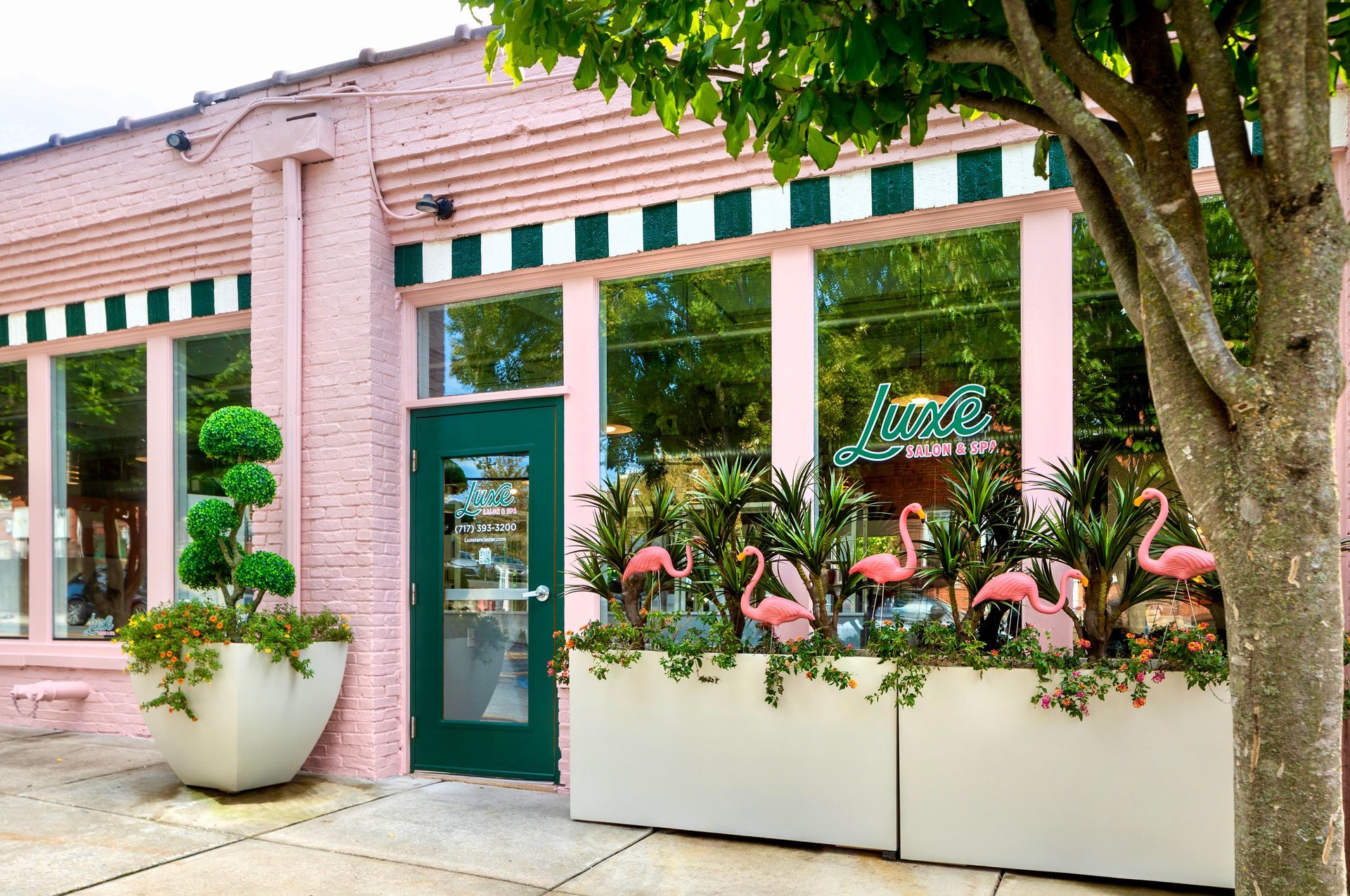 A pink building with flamingos in front of it - luxe salon and spa lancaster entrance