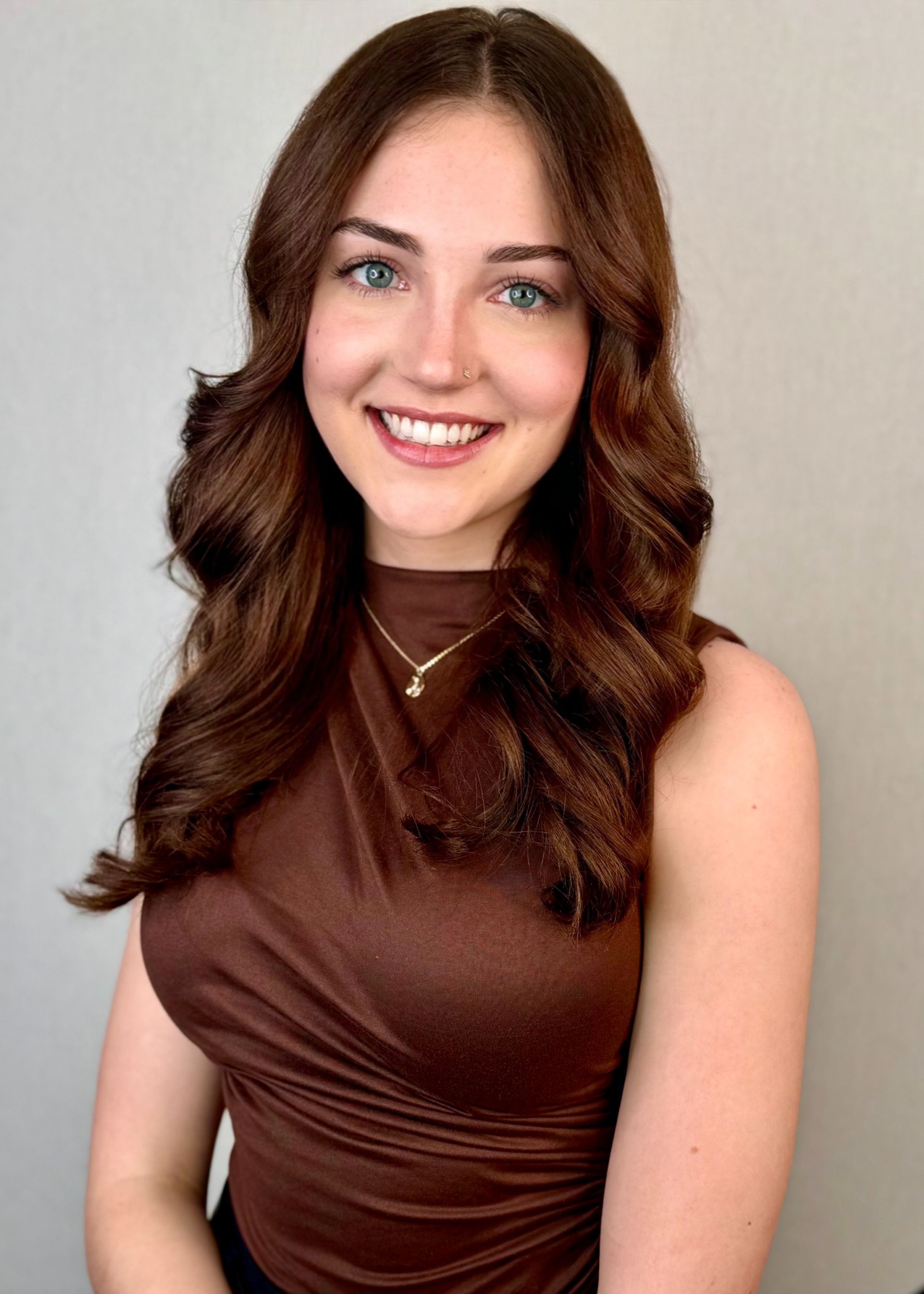 A woman is getting her hair blow dried with a round brush.