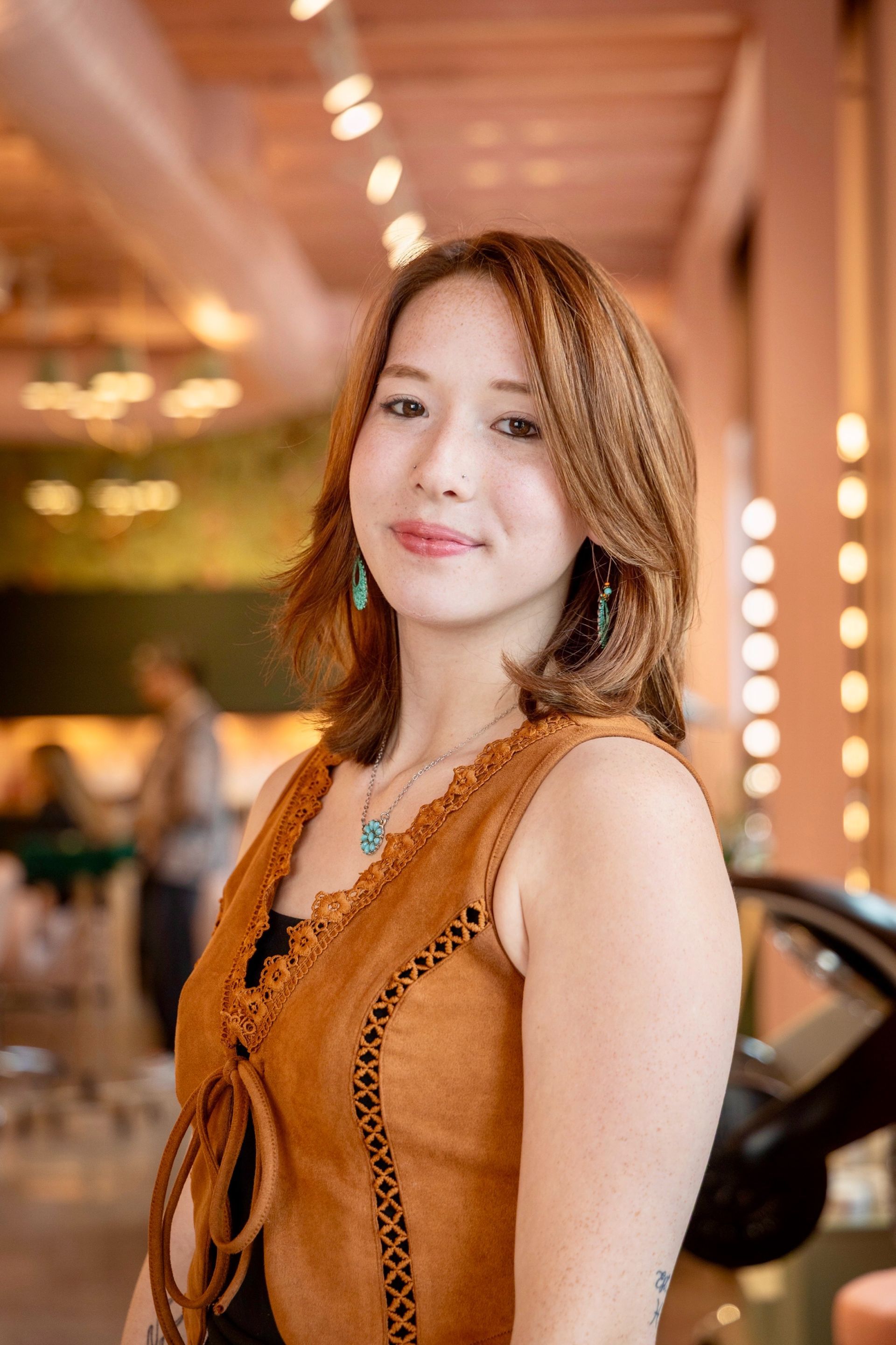 A young woman with red hair is wearing a black sweater.