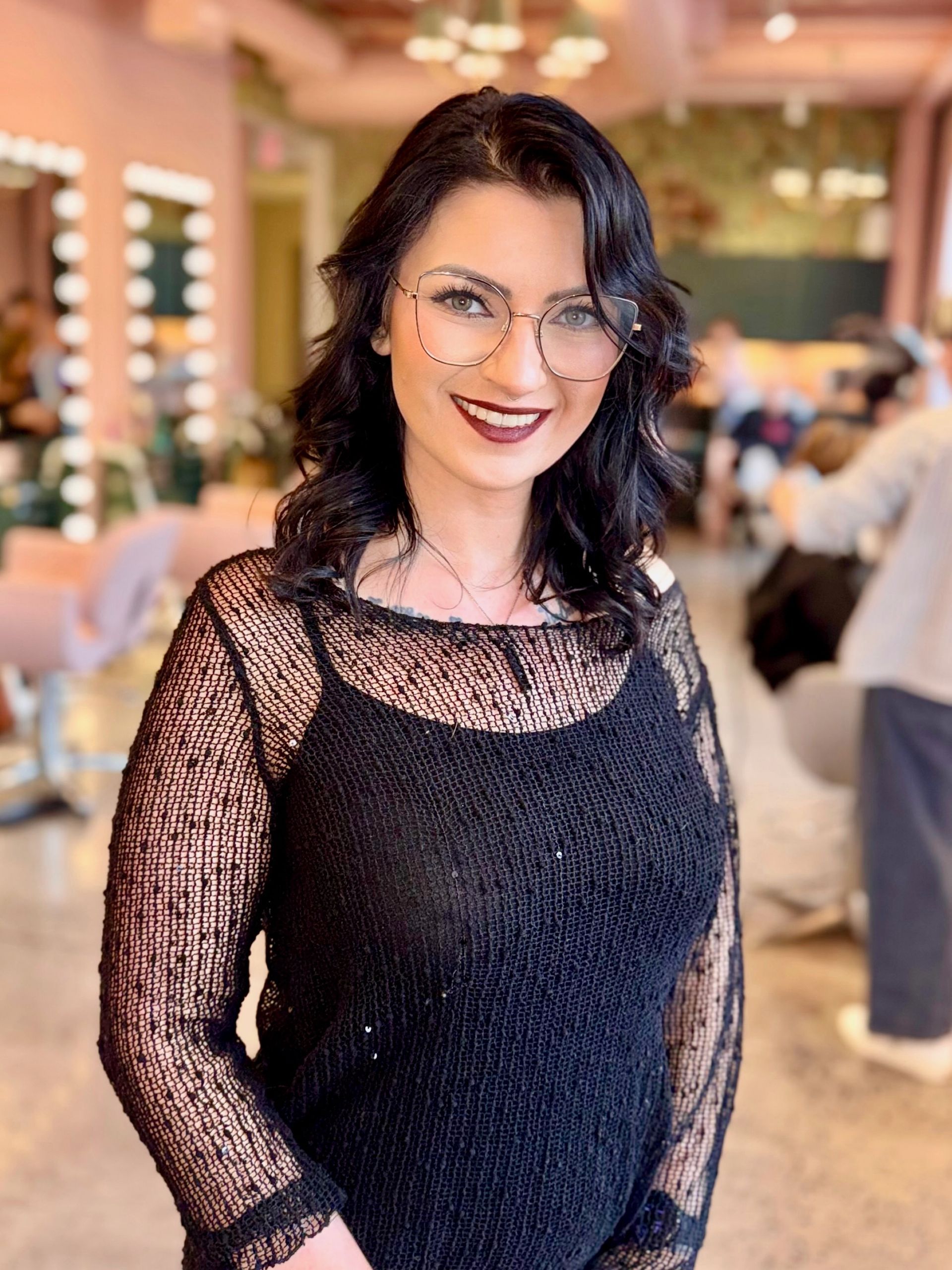 A woman with long hair and bangs is smiling for the camera.