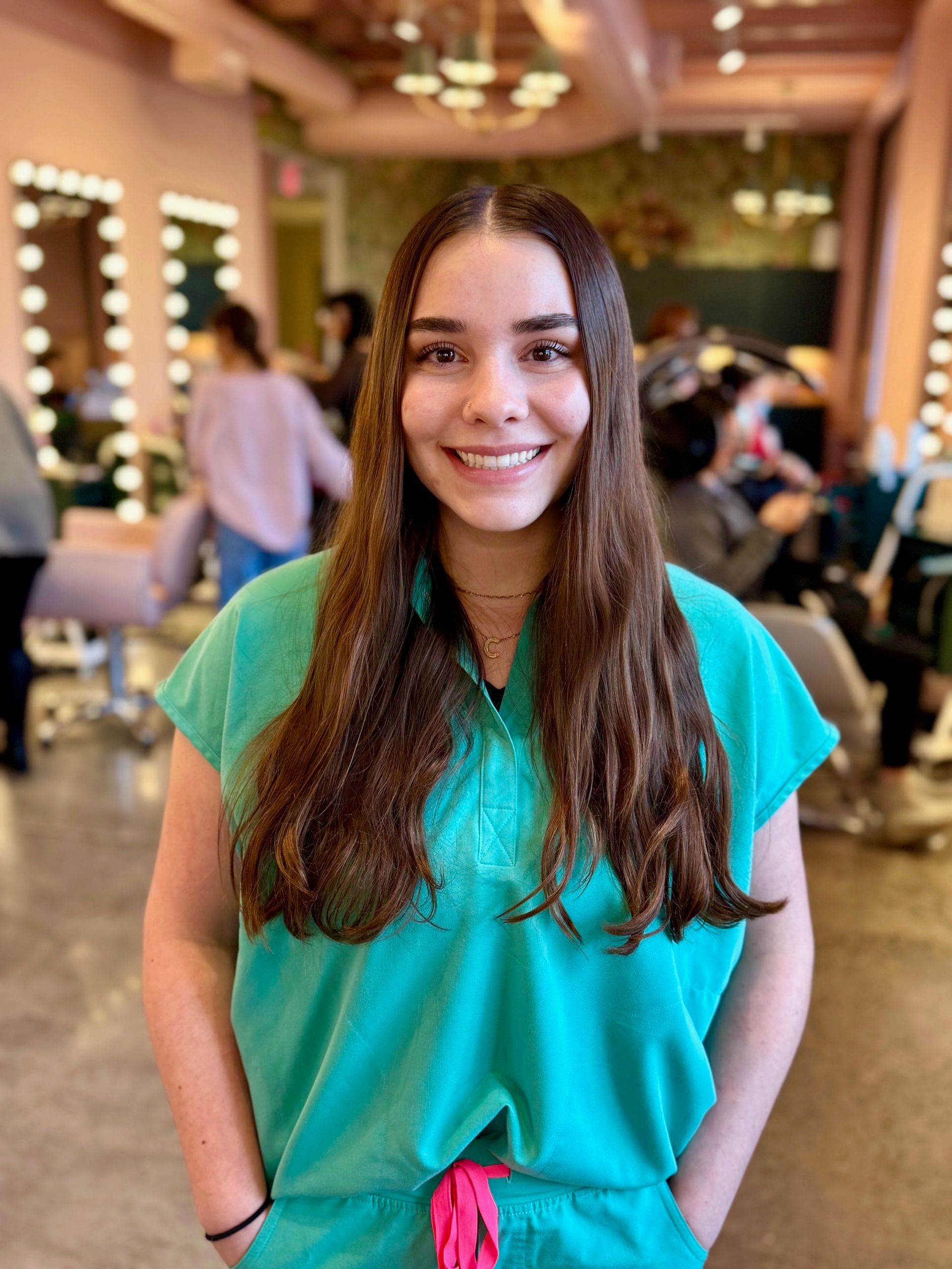 Person receiving a facial massage, relaxed with eyes closed; lit candles in background.